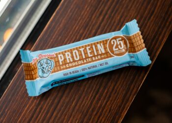 A protein bar rests on a wooden surface.