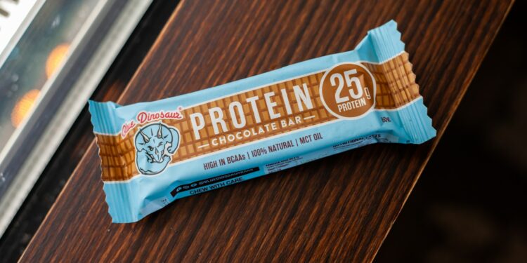 A protein bar rests on a wooden surface.