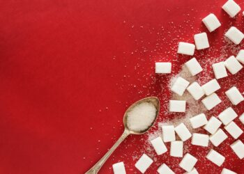 sugar cubes and a spoon on a red surface