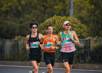 Three runners compete in a marathon race.