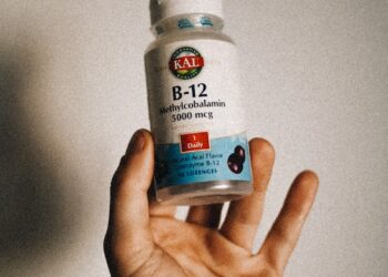 a person holding a bottle of vitamins in their hand