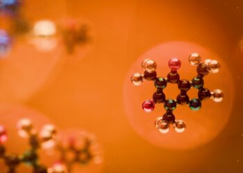 Molecular structures are seen against an orange backdrop.