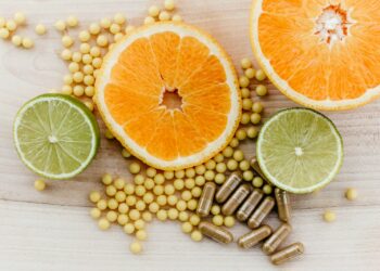 oranges, peas, and limes on a wooden table