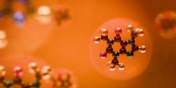 Molecular structures are seen against an orange backdrop.